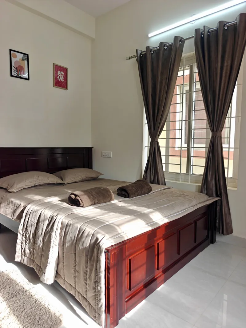 Sunlit air-conditioned bedroom with wooden double bed