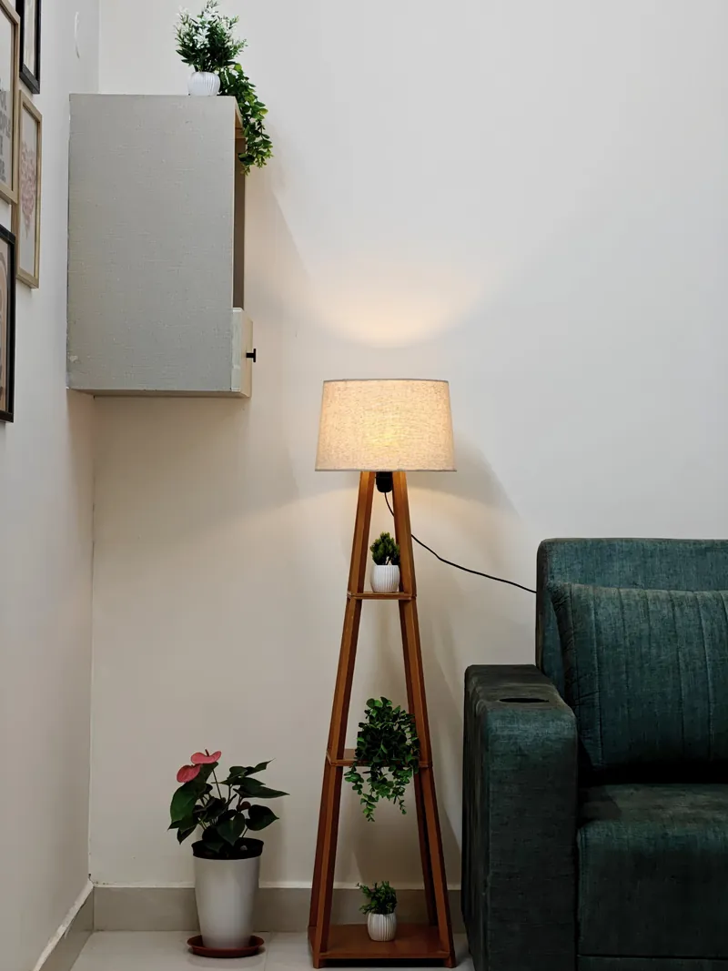 Warm floor lamp beside the green sofa